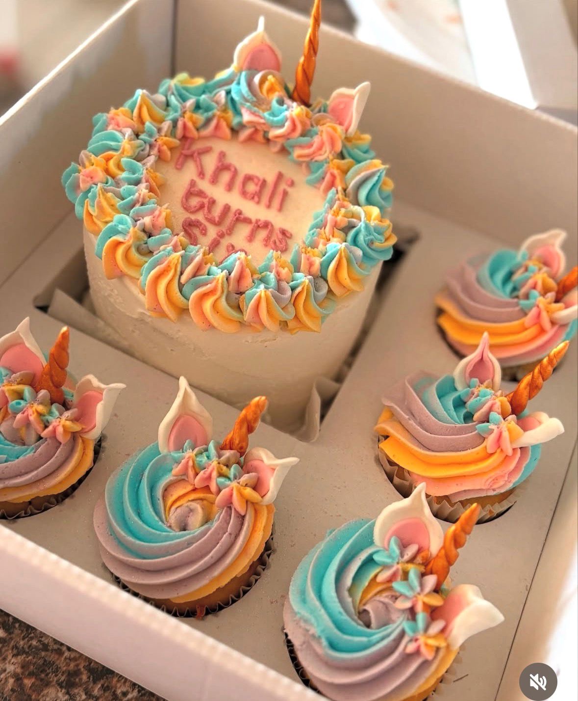 Pastel unicorn themed bento birthday cake with matching unicorn cupcakes for a girl's birthday party